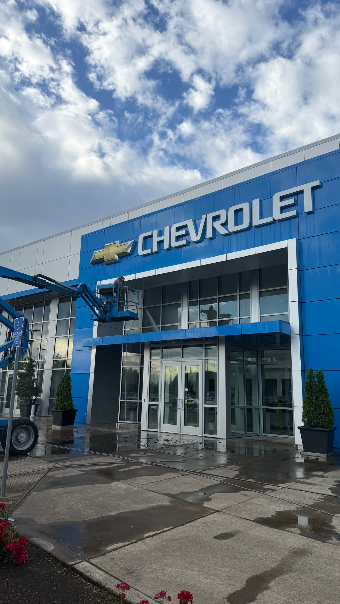 Chevrolet dealership building exterior being pressure washed